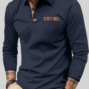 Man wearing a navy long-sleeve polo shirt with plaid accents on a city street.