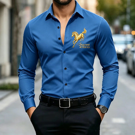 A man wearing a blue long-sleeve button-up shirt with a gold embroidered horse logo and the text 'Success at first try' on the left chest, 