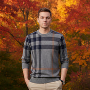 Person wearing a gray and navy plaid sweater against a gray background