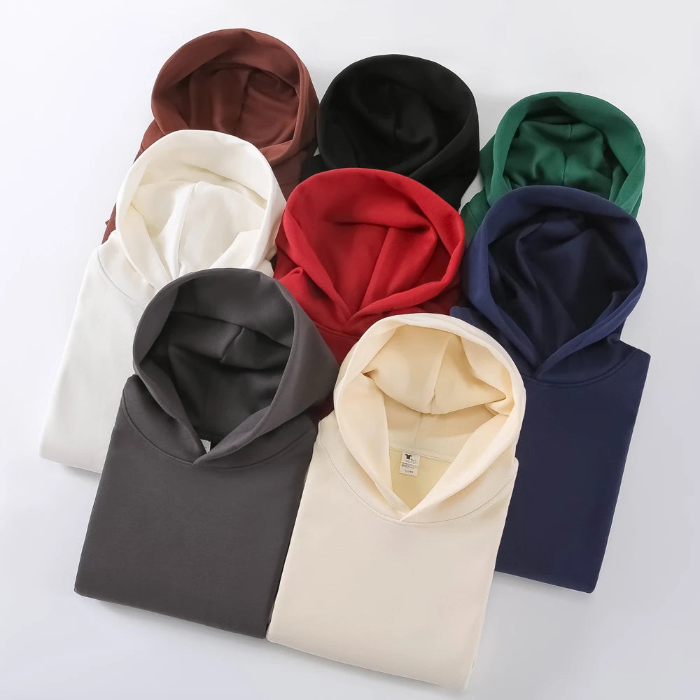 Collection of folded hoodies in various colors on a white background
