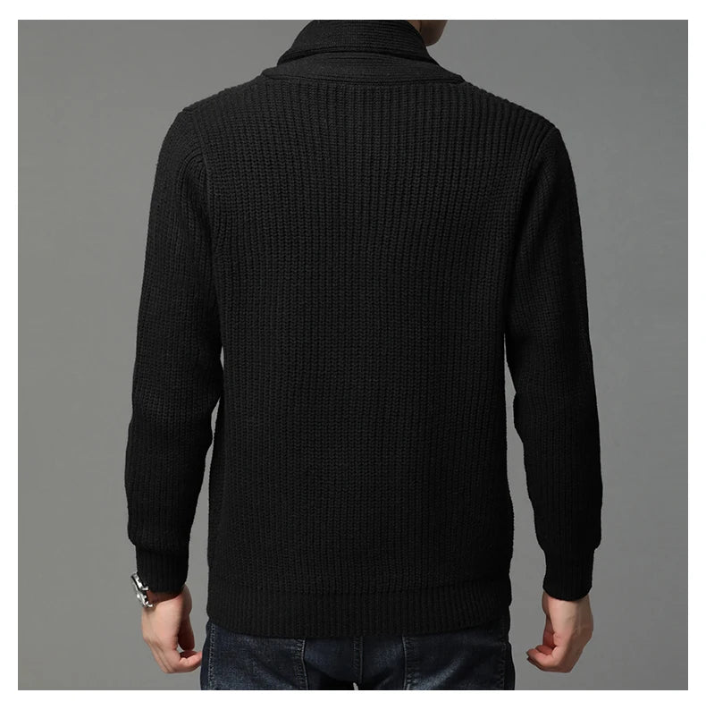 Black ribbed sweater worn by a person on a gray background