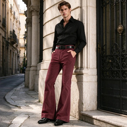 A man stands outdoors against a stone building column wearing a black long-sleeve button-up shirt, dark brown leather belt, and high-waisted maroon flared trousers with black dress shoes.