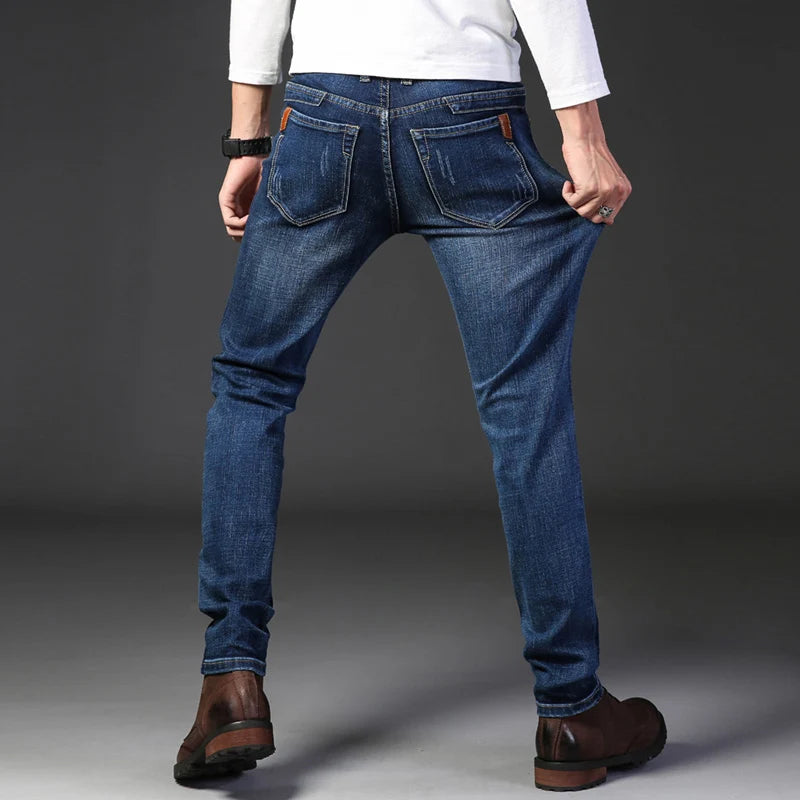 Person wearing blue jeans and a white shirt on a gray background