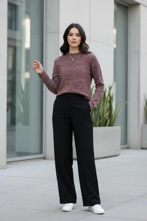 A woman wearing a marled burgundy knit sweater with a crew neck, styled with gold earrings 