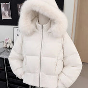 A white puffer jacket with a large fluffy faux-fur trimmed hood, displayed on a mannequin torso in an indoor room setting.