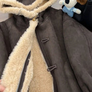 Close-up of a brown hooded jacket held open to show cream fleece-look lining, an inner zipper and outer toggle fastenings