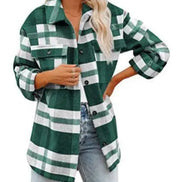 Woman wearing a dark green and white plaid shirt with jeans, against a white background.