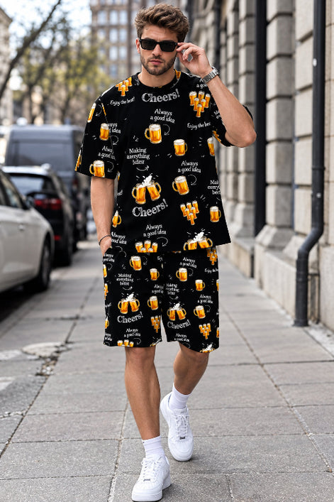 A man walking on a city sidewalk wearing a matching black short-sleeve t-shirt and shorts set with a repeating beer 
