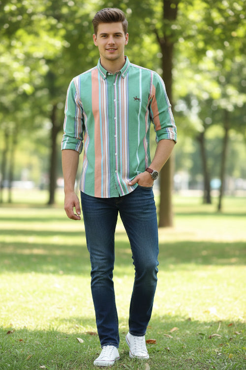 Folded green shirt with multicolored stripes on a white background