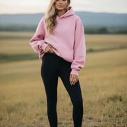 Pink hoodie worn by a person on a white background