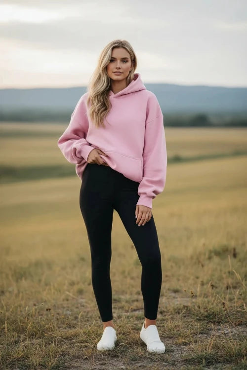 Pink hoodie worn by a person on a white background