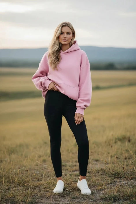 Pink hoodie worn by a person on a white background