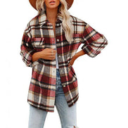 Woman wearing a red and cream plaid shirt with a white top and light jeans, against a white background.