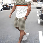A man walking on a city street wearing a white t-shirt with a beige and brown checkerboard pattern 