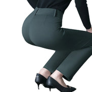 Dark green pants worn by a person on a white background