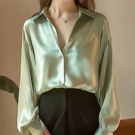 Light green satin button-down shirt worn by a model with a black skirt.