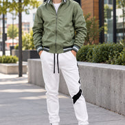 Green jacket and white pants with black accents on a white background