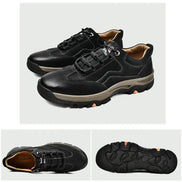 Black leather shoes with brown soles on a light gray background