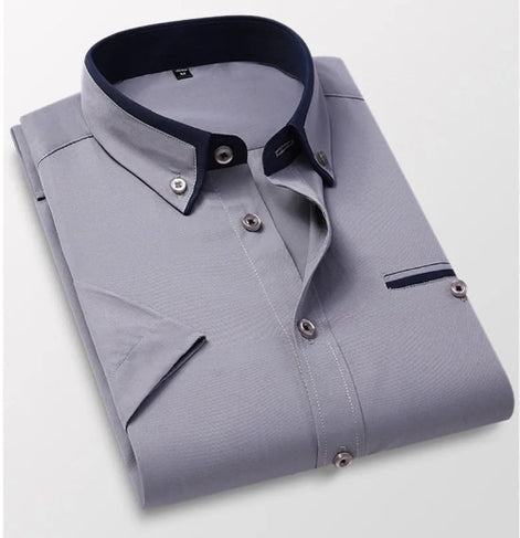 Folded gray dress shirt with navy collar and trim on a light gray background