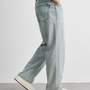 Light blue jeans worn by a person on a plain background