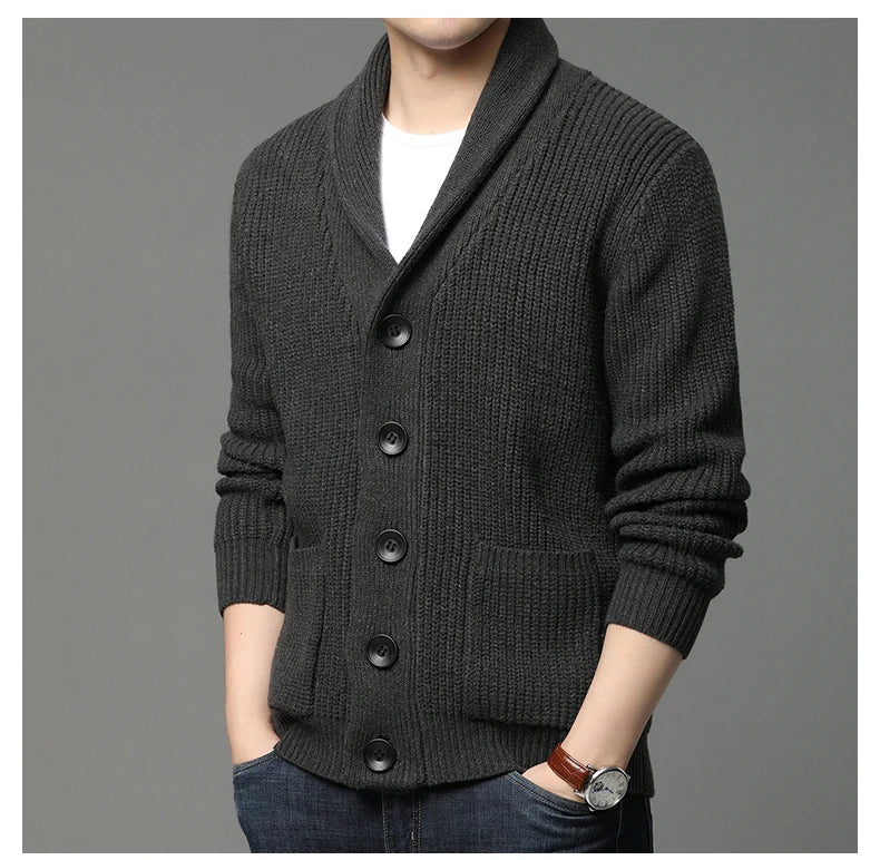 Dark gray knitted cardigan worn by a person on a gray background