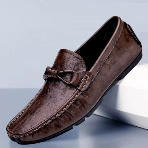 Brown leather loafer shoe on a light gray background