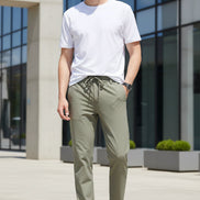 Khaki pants worn by a person on a plain background