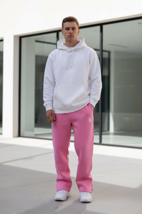 Person wearing pink sweatpants with a logo in a minimal indoor setting