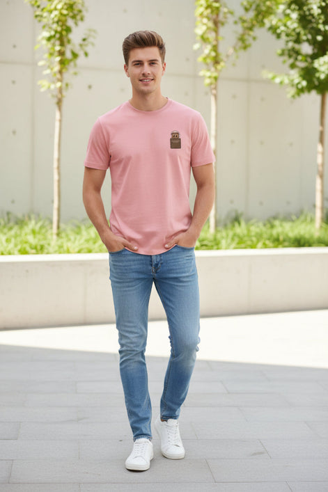 Pink t-shirt with a small brown patch on a hanger against a light background