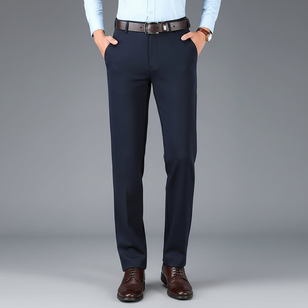 Navy blue dress pants with a brown belt on a gray background