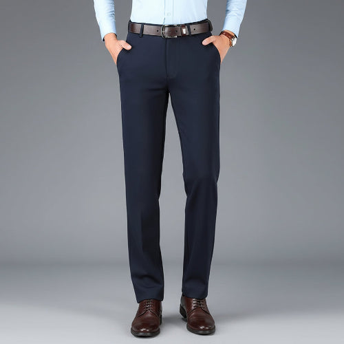 Navy blue dress pants with a brown belt on a gray background