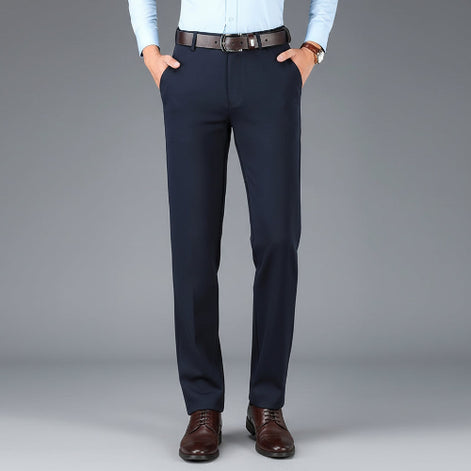 Navy blue dress pants with a brown belt on a gray background
