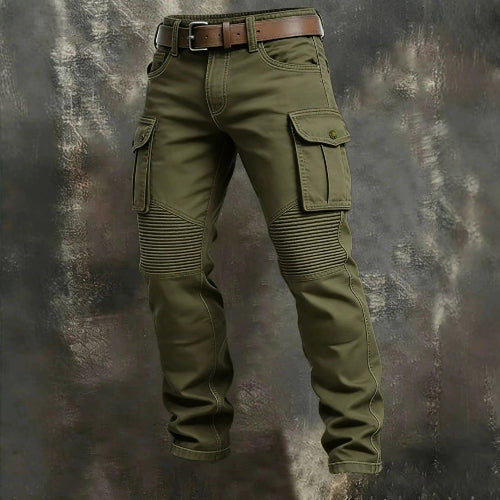 Olive green cargo pants with flap thigh pockets, ribbed knee panels, and a brown belt against a textured gray background.