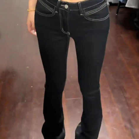 Person wearing a black top and black jeans in a fitting room.