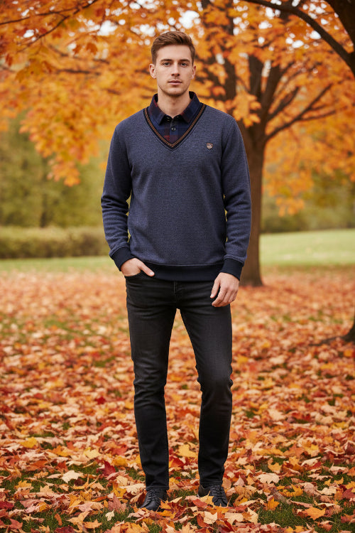Folded blue sweater with plaid shirt collar on a snowy background