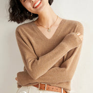 Woman wearing a brown sweater with 'Cashmere' branding on a light background