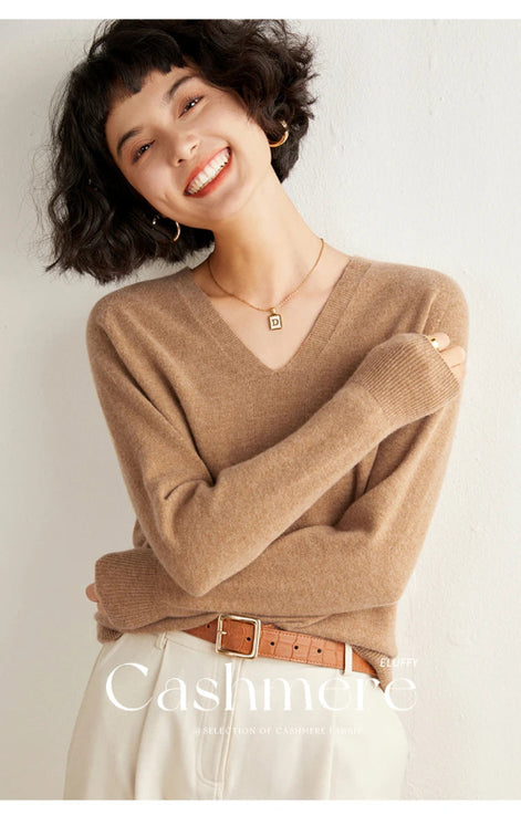 Woman wearing a brown sweater with 'Cashmere' branding on a light background