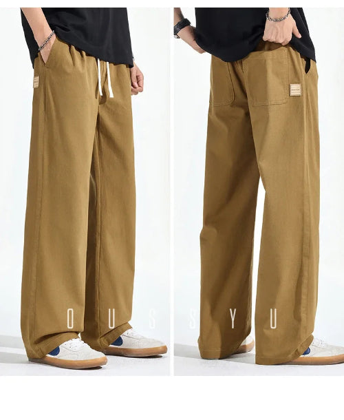Front and back views of a model wearing khaki loose-fit straight-leg pants, showing a white drawstring, side pockets, and back patch pockets with a small sewn-on label.