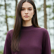 Person wearing a purple sweater with a blurred background