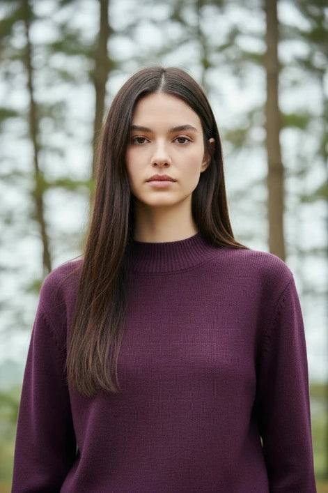 Person wearing a purple sweater with a blurred background