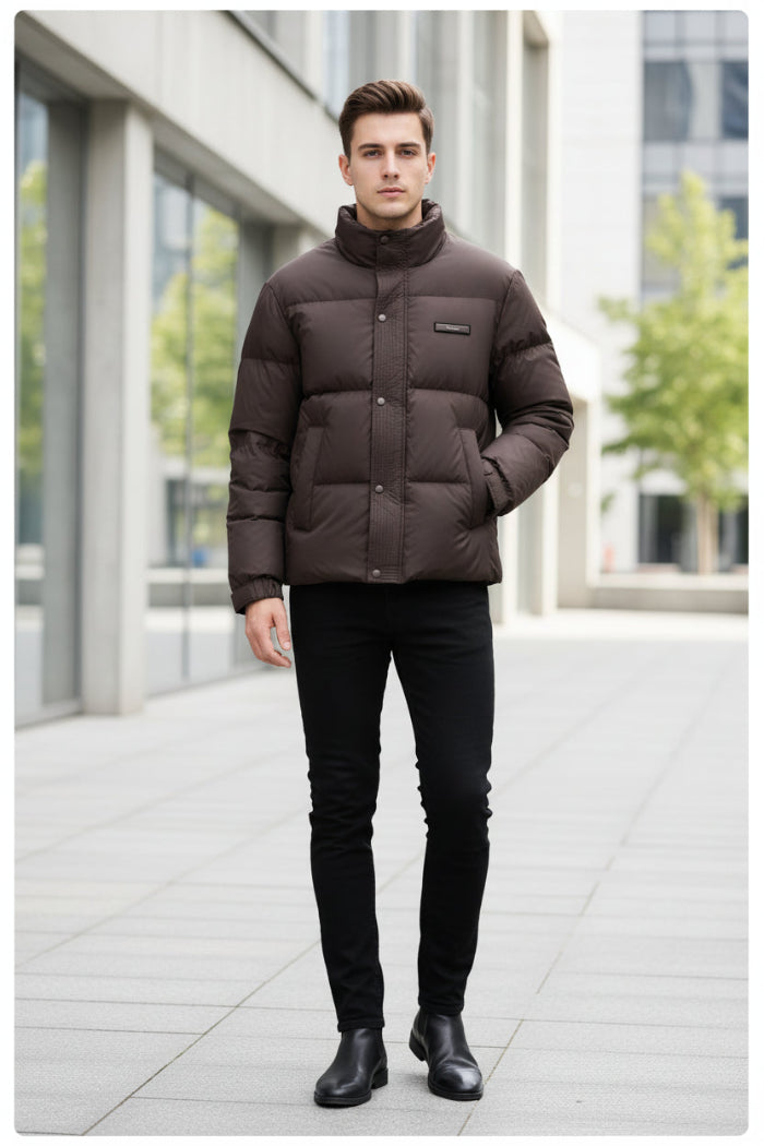 A dark brown puffer jacket with a high stand-up collar and front button closure, displayed on a hanger in a retail store setting.