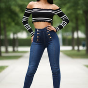 Woman wearing a black and white striped off-shoulder top and blue jeans 
