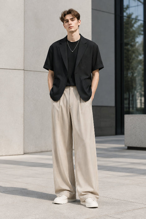 A men's two-piece outfit set featuring a black short-sleeve blazer layered over a black t-shirt, paired with high-waisted beige wide-leg trousers, 