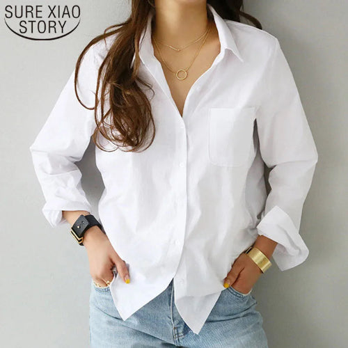 White long-sleeve button-down shirt worn by a model with hands in jeans pockets.