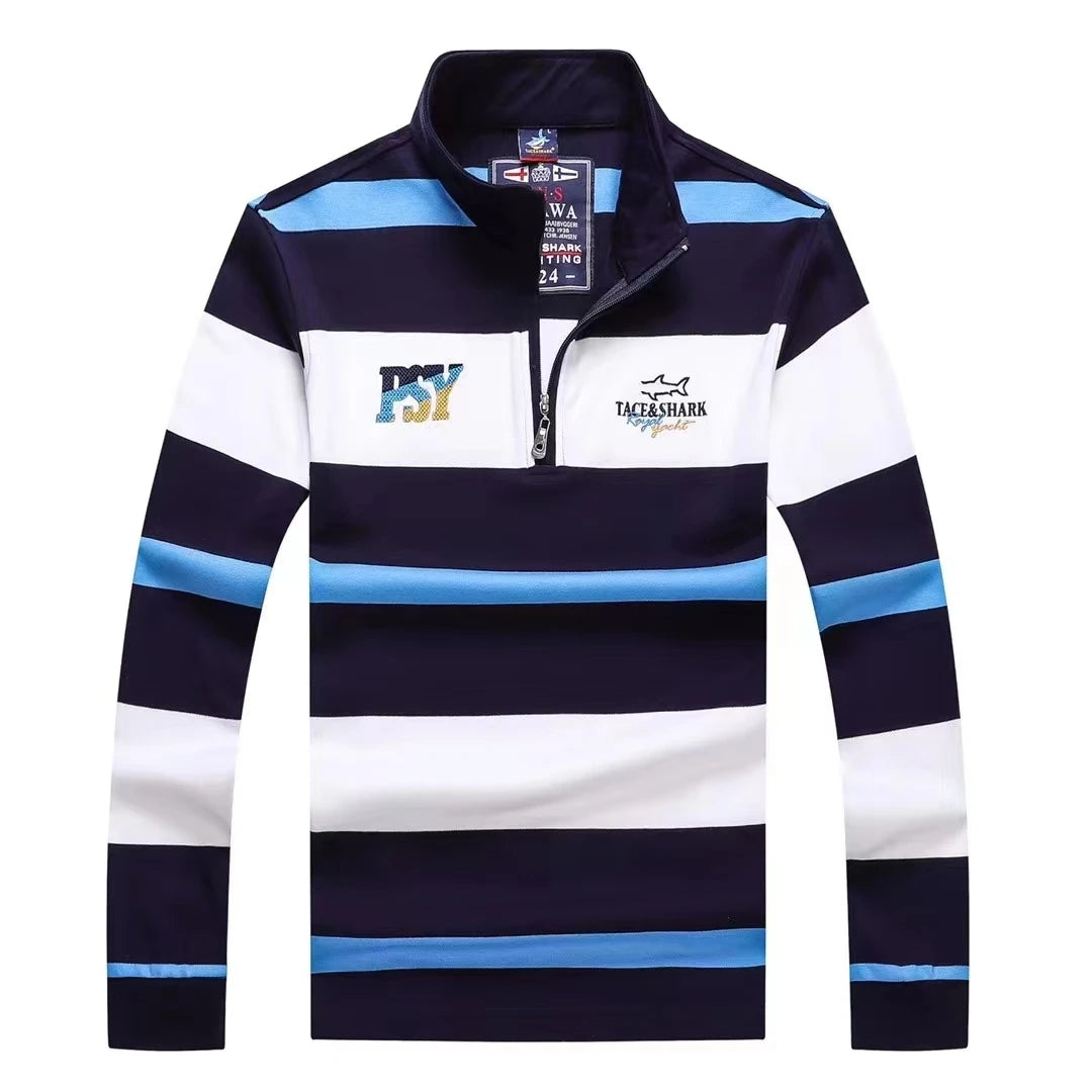 A men's long-sleeve quarter-zip pullover with horizontal navy, white, and light blue stripes. The left chest features a colorful 'NY' graphic, and the right chest features a 'TASSHARK' shark logo.
