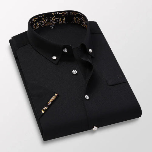 Folded black dress shirt with floral collar and cuff on a light gray background