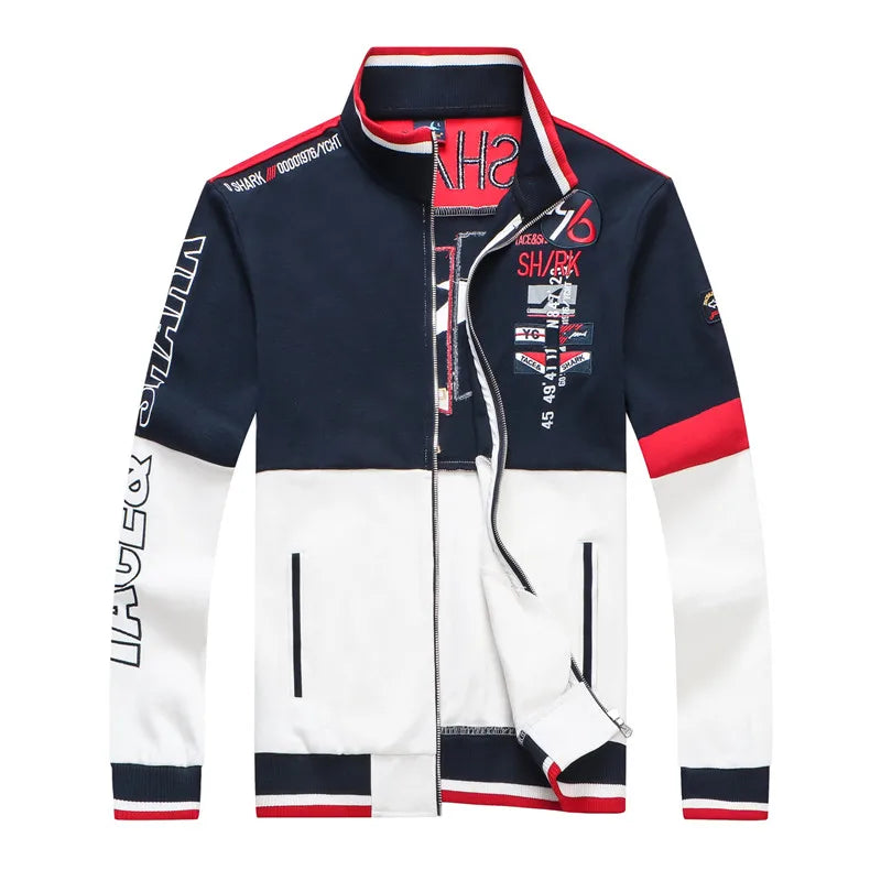 A men's zip-up track jacket with a color-blocked design in navy blue, white, and red. The jacket features graphic prints with text including 'SHARK' and 'UPFECOR' on the front and sleeves, a high collar, and zippered hand pockets.