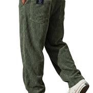Green corduroy pants worn by a person on a white background