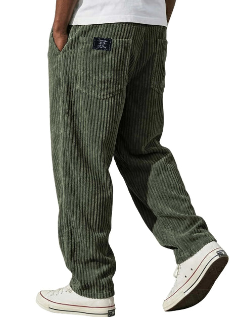 Green corduroy pants worn by a person on a white background