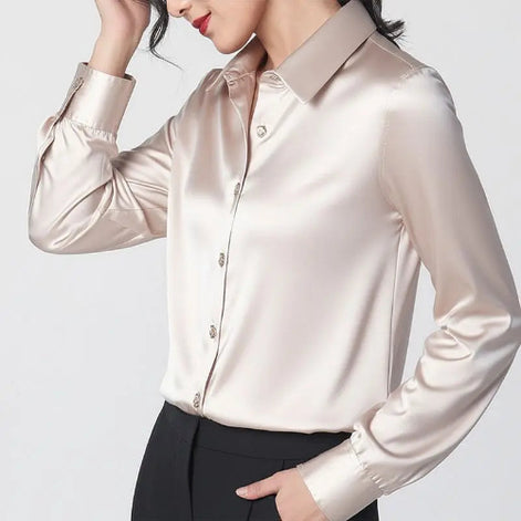 Champagne silk shirt worn by a model posing with one hand in a pocket.